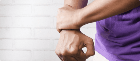 A person is holding their wrist in the air.
