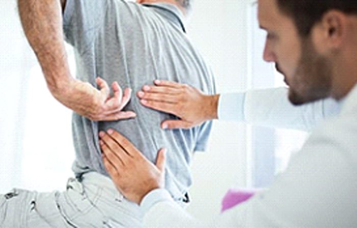 A man with his back turned and another person touching the back of him.