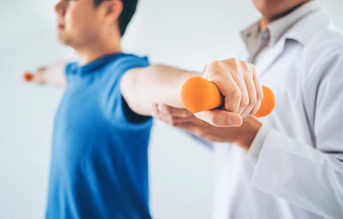 A man holding two orange dumbbells in his hands.