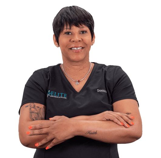 A woman with her arms crossed in front of a black background.