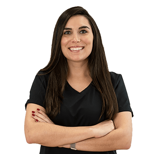 A woman with her arms crossed in front of a black background.