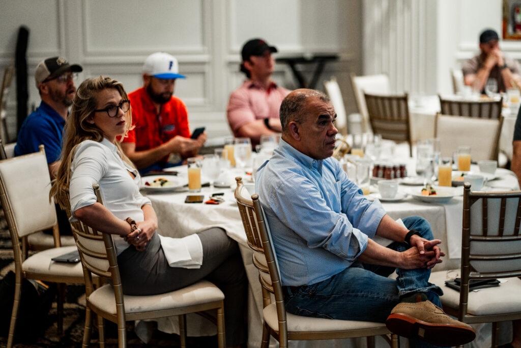 A group of people sitting at tables with plates.