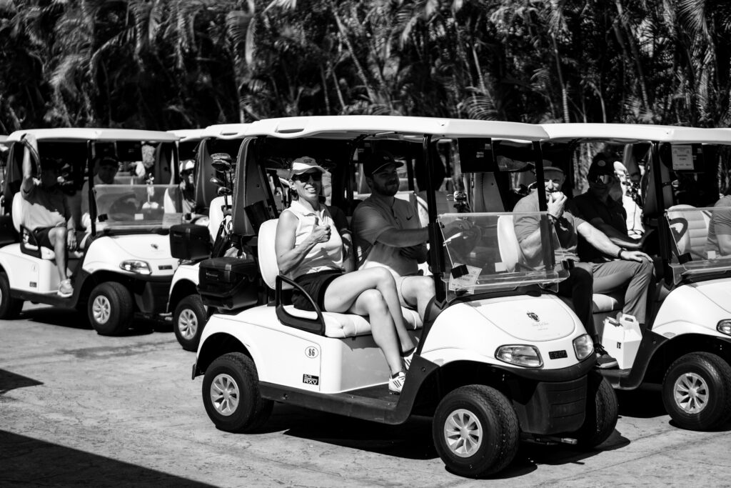 A group of people in golf carts on the road.