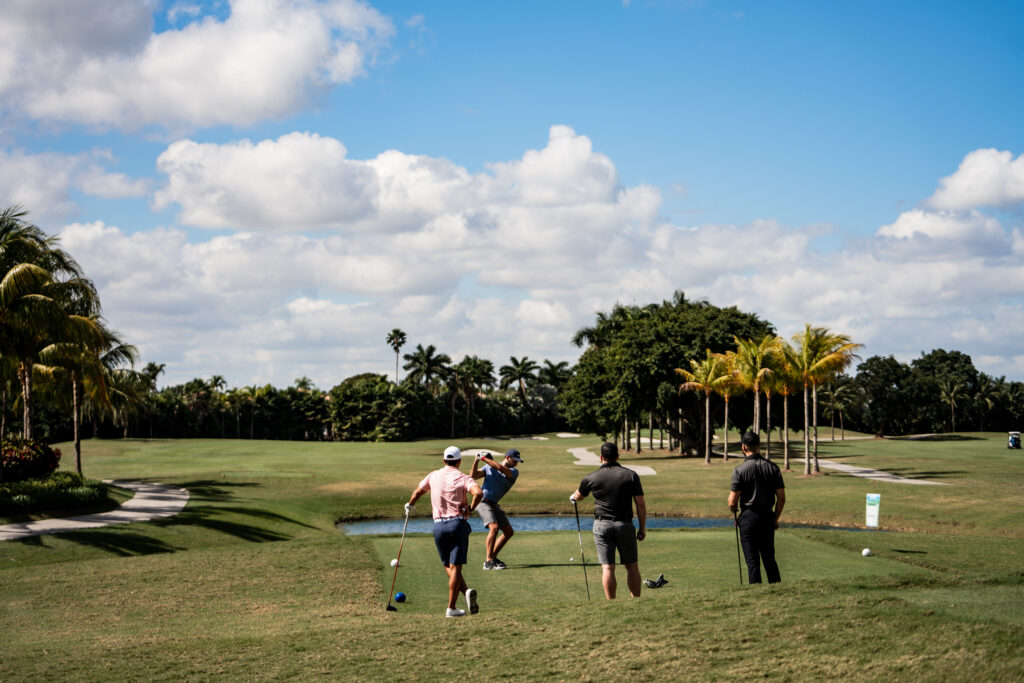 A group of people playing golf on the green.