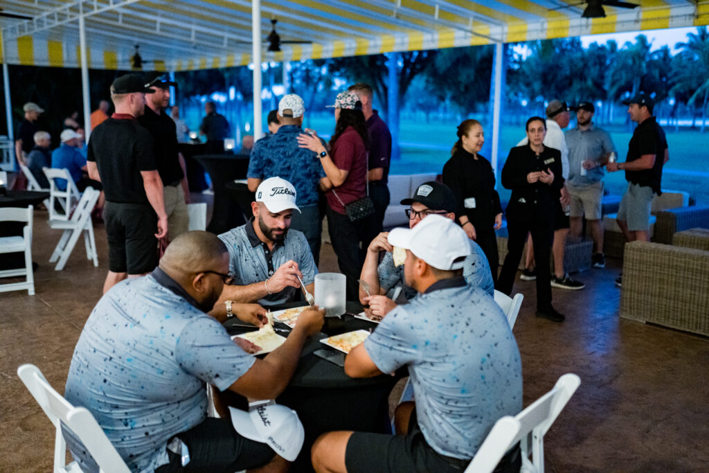 A group of men sitting at tables playing cards.