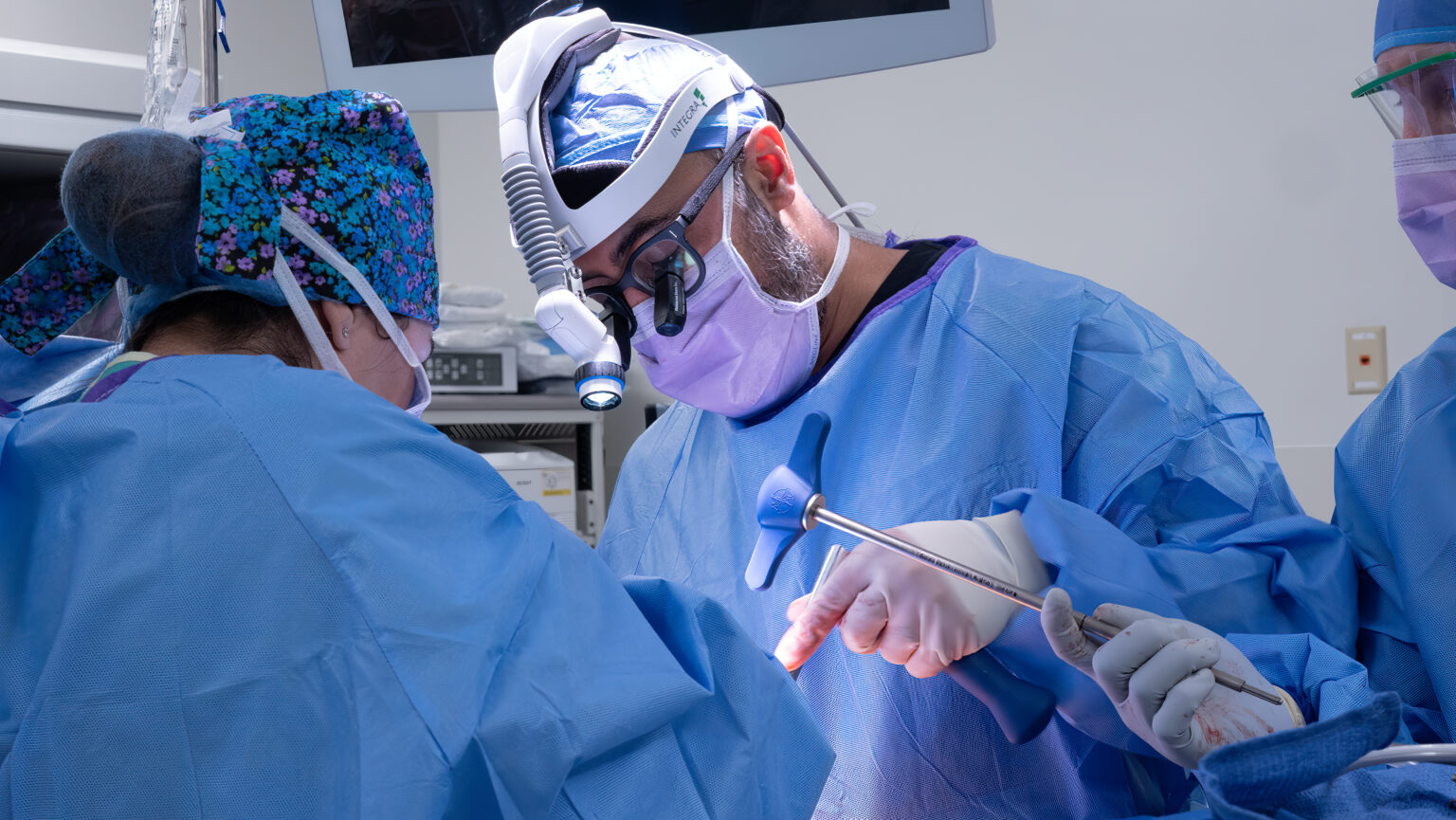 A surgeon is performing surgery on someone in the operating room.