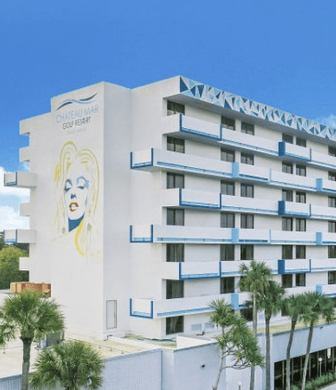 A large white building with a mural of marilyn monroe on the side.