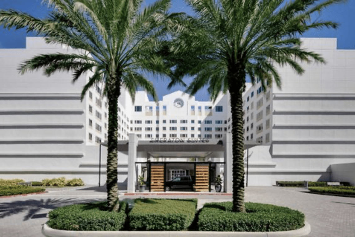 A building with palm trees in front of it.